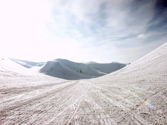 Through a cold mountain pass with snowmobiles.