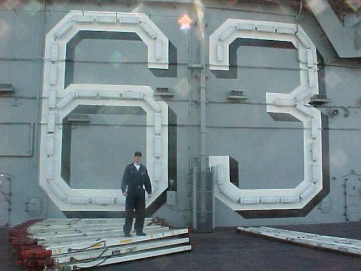 Darren Drake standing next to the tower on the uss kitty hawk